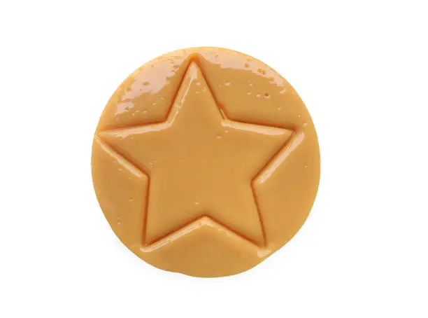 Photo of Dalgona candy or Ppopgi. Sugar Honeycomb cookie with star shape on white background with clipping path. candy challenge