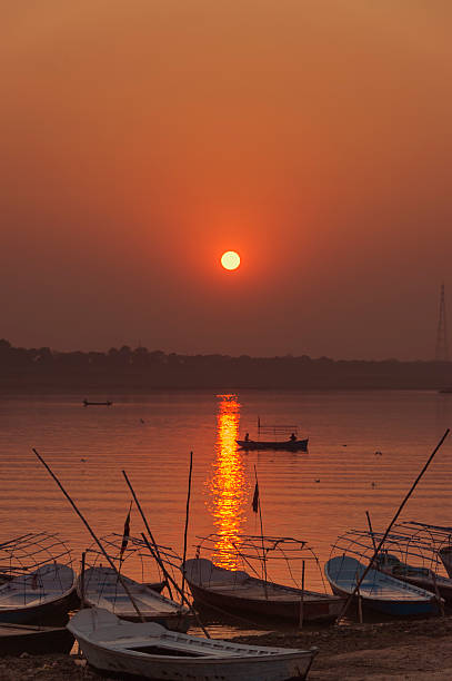 row boats at sunset on river Yamuna, Allahabad, India Last rays of sun on Ganges with row boats lined up on the river Yamuna, Allahabad, India prayagraj photos stock pictures, royalty-free photos & images