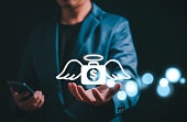 Angel investor concept. Businessman holding money bag icon with wing