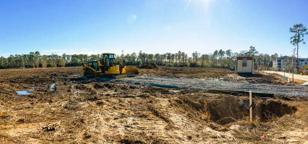 istock Construction site: filling gravel and clearing by yellow bulldozer grader. Flat plot making on dirty construction site in sunny day 1483452242