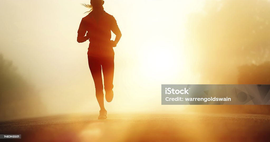 Athlete running road silhouette Runner athlete feet running on road. woman fitness silhouette sunrise jog workout wellness concept. Running Stock Photo