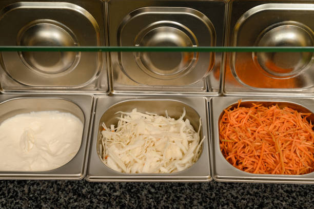 istock Dishes for ready-made chopped vegetables on the surface of a work table in a fast food restaurant 1483460220