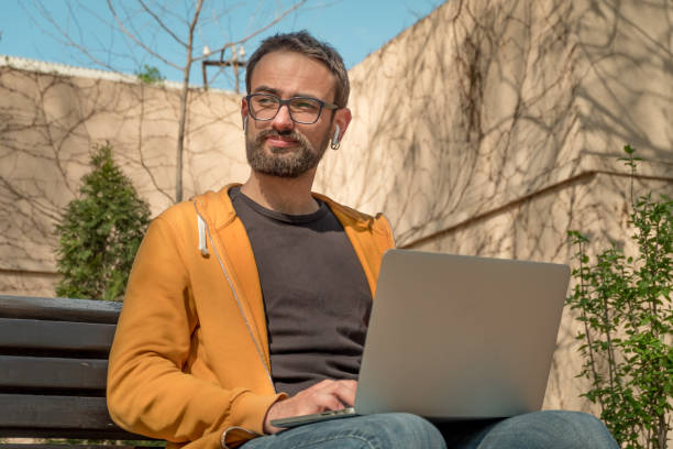 istock Young Man Using His Laptop Outdoors 1483460663