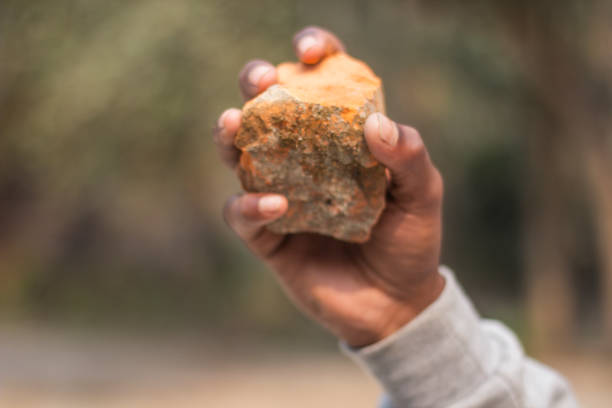 istock One hand holds a piece of brick and the background is blurred 1483465419