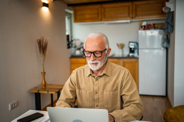 istock An elderly man, a pensioner, learns online, he spends his retirement days studying online, thus continuing his activities and still perfecting his skills. 1483466735