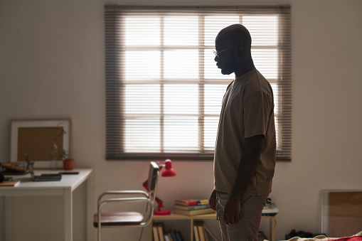 African American man in depression standing alone in the room