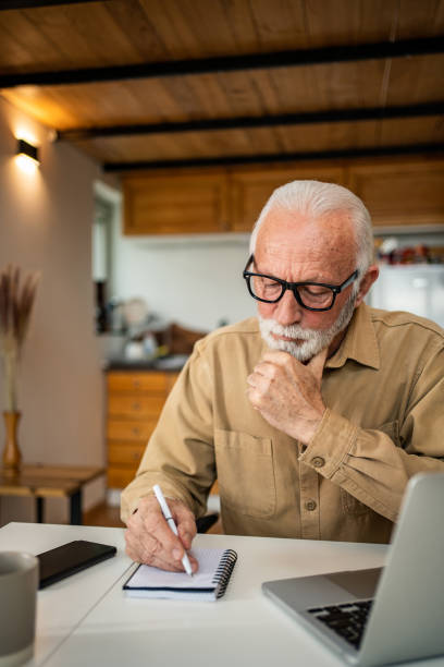 istock An elderly man, a pensioner, learns online, he spends his retirement days studying online, thus continuing his activities and still perfecting his skills. 1483467397