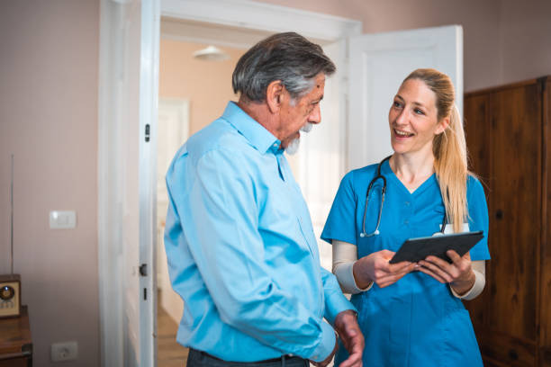 istock Cheerful Caucasian Nurse At Patients Home Using Digital Tablet 1483467707