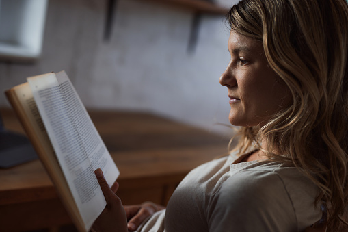 Young woman enjoying while reading a book at home.