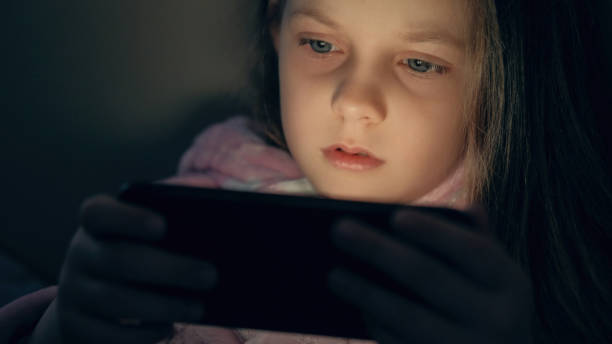 Child gadget night girl watching video on phone stock photo Child gadget night girl watching video on phone stock photo