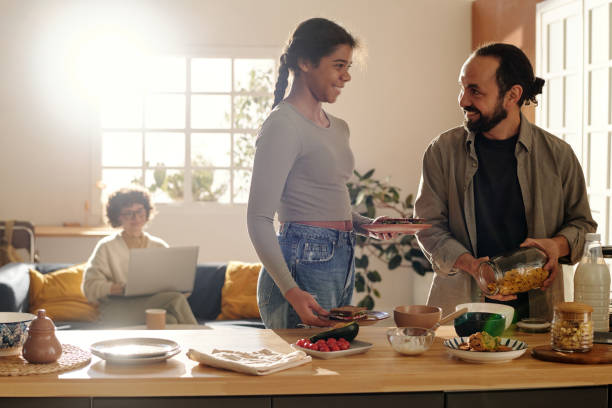 istock Adopted daughter helping to her dad in the kitchen 1483472773