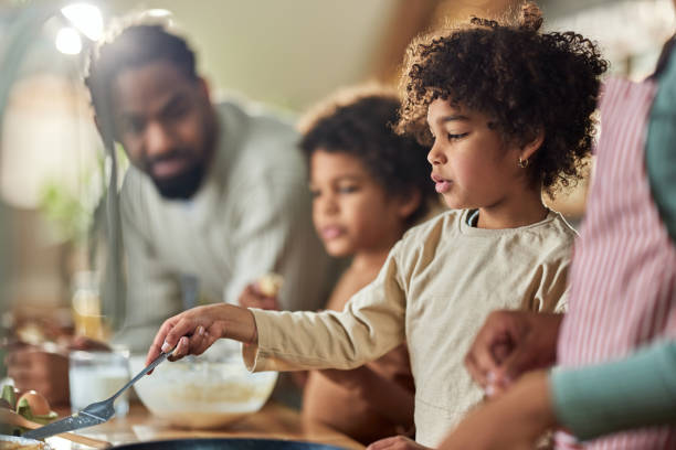 istock Black girl and her family preparing food in the kitchen. 1483473165