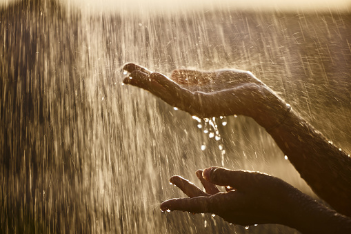 Close up of unrecognizable woman holding her hands under falling water. Copy space.