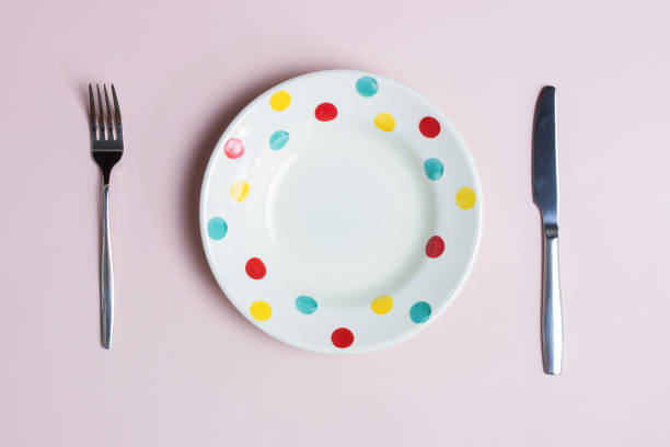 istock Diet concept with empty plate, fork and knife over the pink background. 1483482926