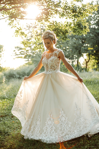 Beautiful young bride enjoying sunny day in nature