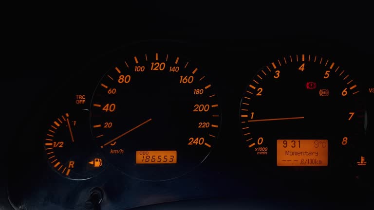 Black car dashboard with yellow backlight during engine starting