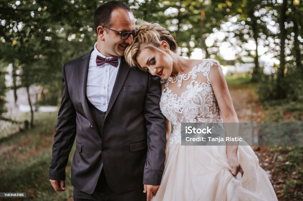 Happy newlyweds holding hands and walking in nature Bride Stock Photo