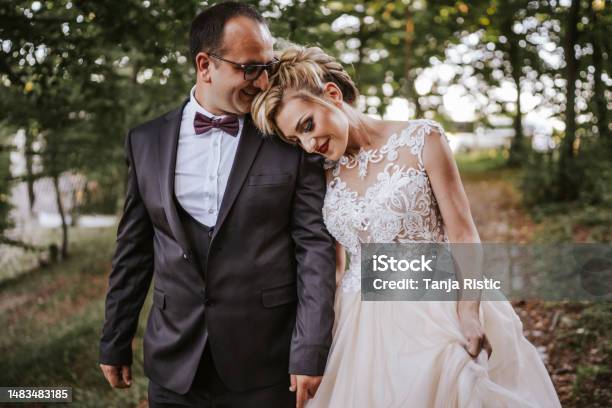 Happy Newlyweds Holding Hands And Walking In Nature Stock Photo - Download Image Now