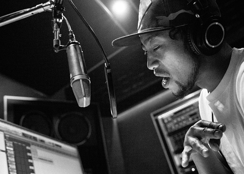 In a modern recording studio, a young New Zealand rapper creates his own song. A inspiring and concentrate moment.