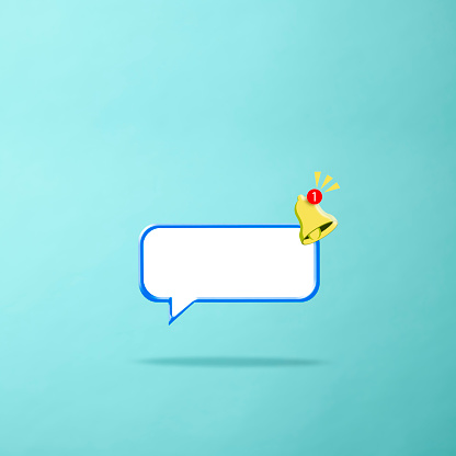 Close-up of speech bubble with yellow ringing bell against light blue background.\nNotification of a call and sms and for social media reminder.