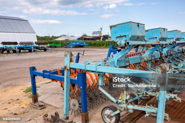 Old Trailed Seeder Are Standing Near The Arches Hangar On The Material And Technical Base Of The Agricultural Enterprise Farm Enterprise In Central Region Of Ukraine Stock Photo - Download Image Now