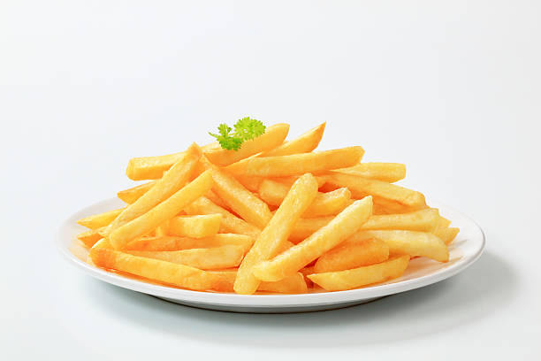 Plate of delicious looking French fries Heap of French fries on a plate french fries stock pictures, royalty-free photos & images