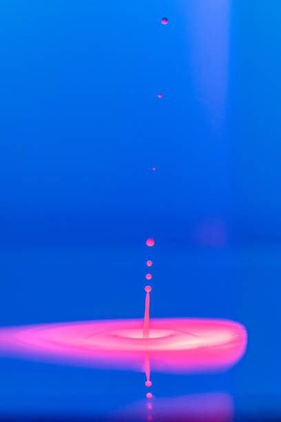 istock A drop falls into a thick liquid with a blue-pink background. Abstract colorful background. 1483497430