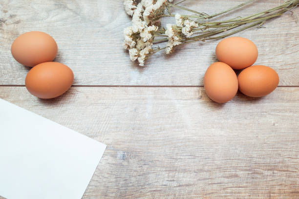 istock Easter rustic banner with copy space and a greeting card. Brown chicken eggs with white flowers on a brown background. 1483499170