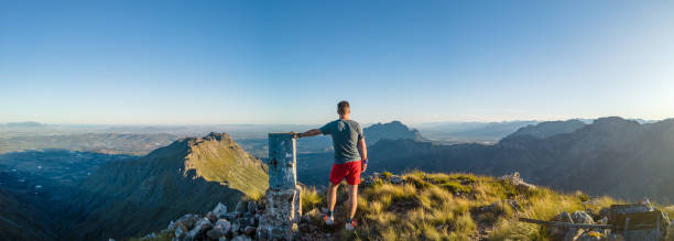 istock Panorama Hiker standing on Mountain Peak at Beacon Cairn looking out 1483500784