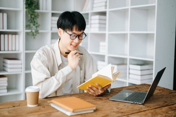 istock Handsome and talented young Asian man student working on his project assignment, using laptop and tablet to search an online informations. 1483503630