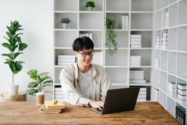 istock Handsome and talented young Asian man student working on his project assignment, using laptop and tablet to search an online informations. 1483503636