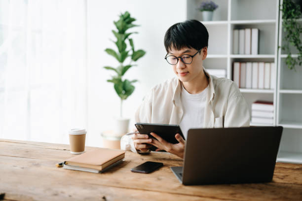 istock Man freelancer is working her job on computer tablet and laptop Doing accounting analysis report real estate investment data, Financial at office 1483503679