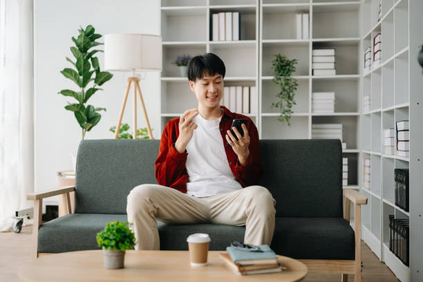 istock Young attractive Asian man smiling thinking planning writing in notebook, tablet and laptop working from home  at home office 1483503765