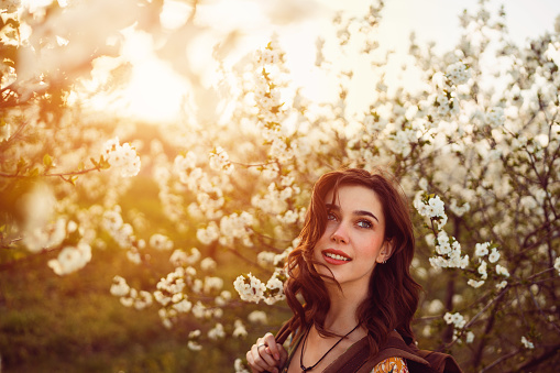 Spring portrait of beautiful young woman in blossoming orchard.