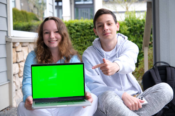 istock Cheerful hipster guys keyboarding information on internet websites via modern computer.Students watching webinar on macbook laptop with blank screen area for your advertising text message 1483507585