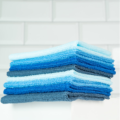 A pile of colorful soft microfiber towels on a white table