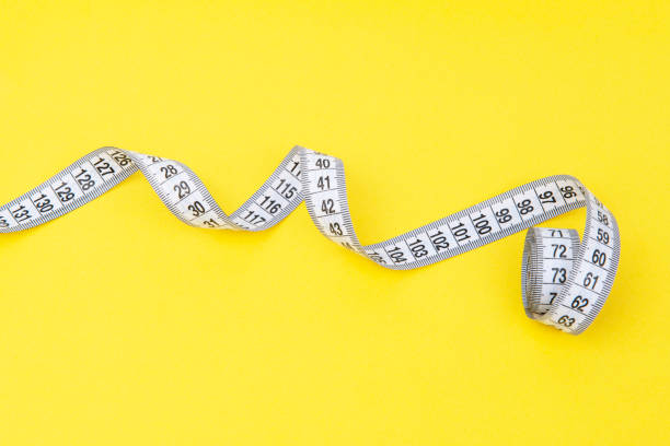 istock white tape measuring isolated on a yellow background 1483508951