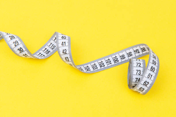 istock white tape measuring isolated on a yellow background 1483510109