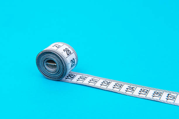 istock white tape measuring on a blue background with copyspace 1483510253