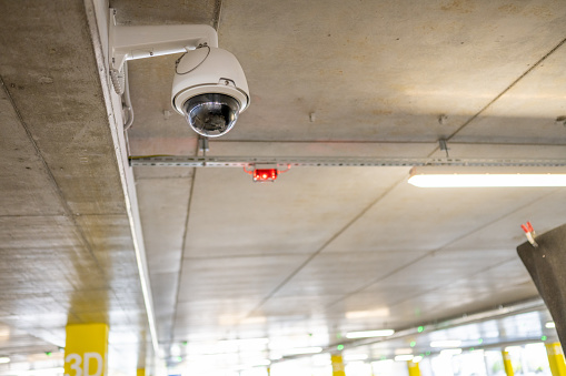 Low angle view of surveillance camera in underground parking space.