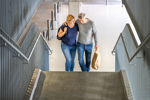 Couple arms around while ascending stairway.