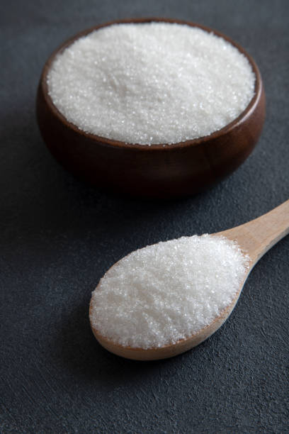 istock Granulated sugar in bowl on black background 1483519192