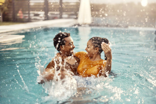istock Cheerful black couple having fun in the swimming pool. 1483519571
