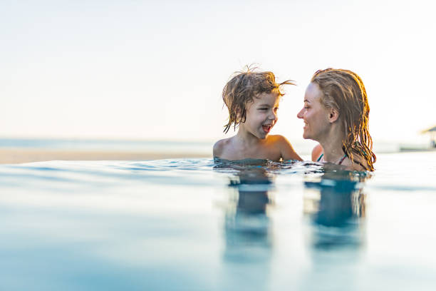 istock Happy single mother and her boy talking in the pool. 1483520305