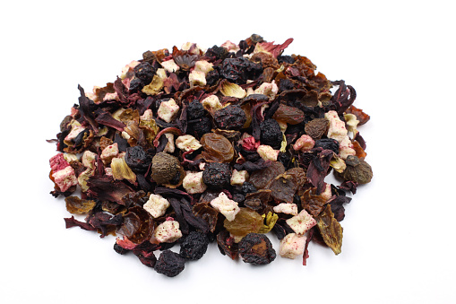 Pile of Fruit tea on a white background. Mix of fruit pieces, hibiscus petals and berries for tea. dry herbal tea with fruits raisins, blueberries, strawberries.