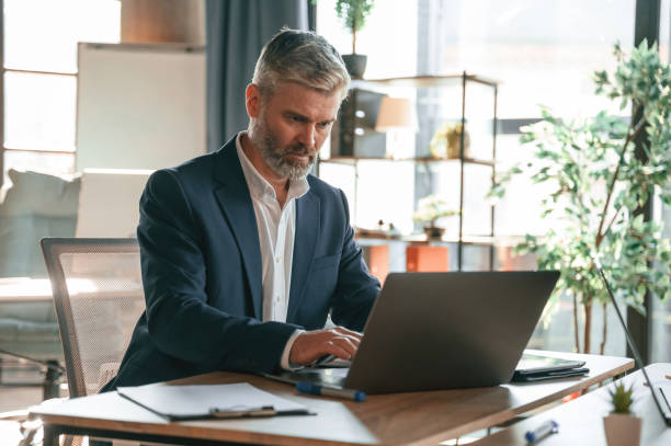 istock Using laptop. Senior businessman is working in the office 1483521944