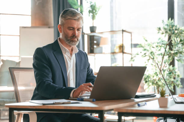 istock Using laptop. Senior businessman is working in the office 1483521975