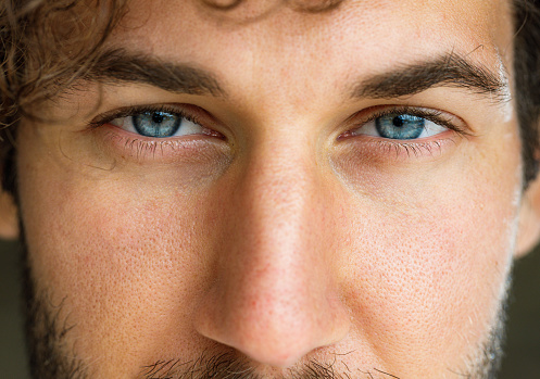 Close up of man's blue eyes looking at camera.