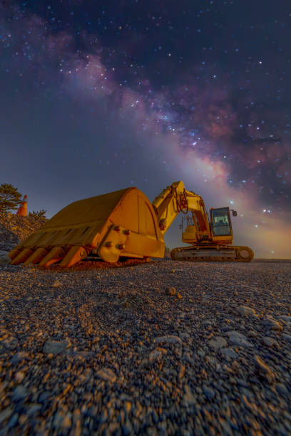 istock excavator parking under the night sky with milkyway view. 1483523825