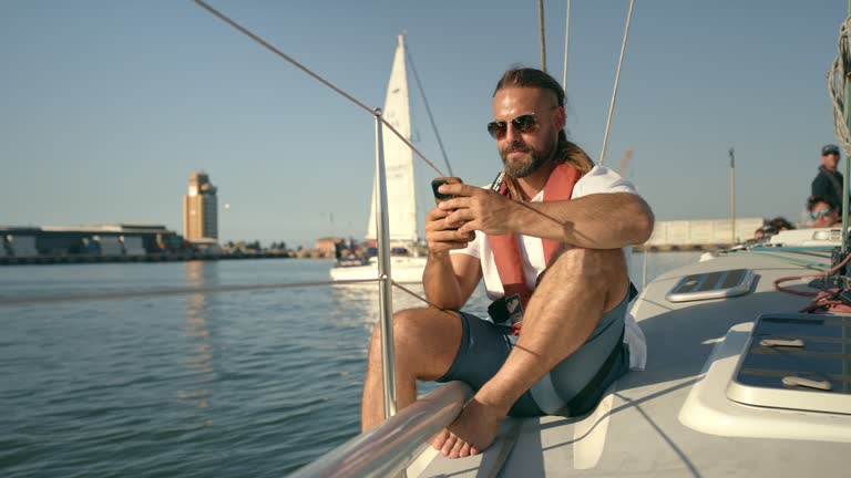 Phone, man and texting on boat on holiday, vacation or summer trip in ocean. Cellphone, yacht and person on social media, online browsing or web scrolling for travel, tourism and sea cruise on ship.